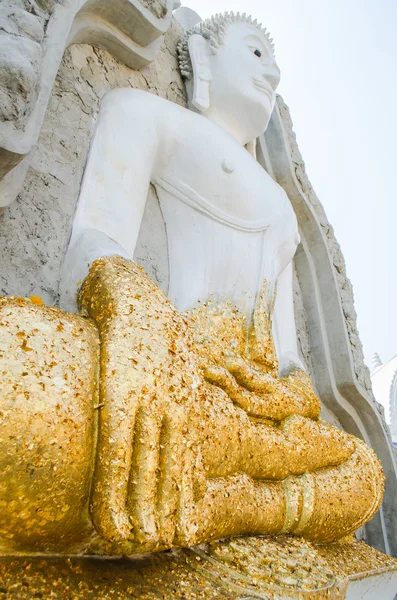 Гигантская белая статуя Будды на каменной стене — стоковое фото