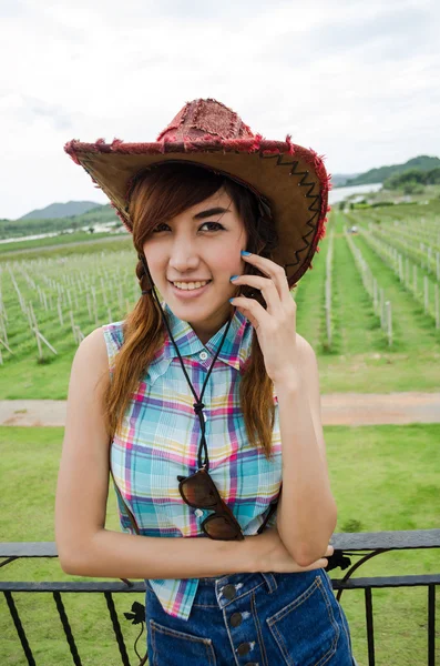 亚洲女性对绿色的田野穿着蓝格子衬衫 — 图库照片