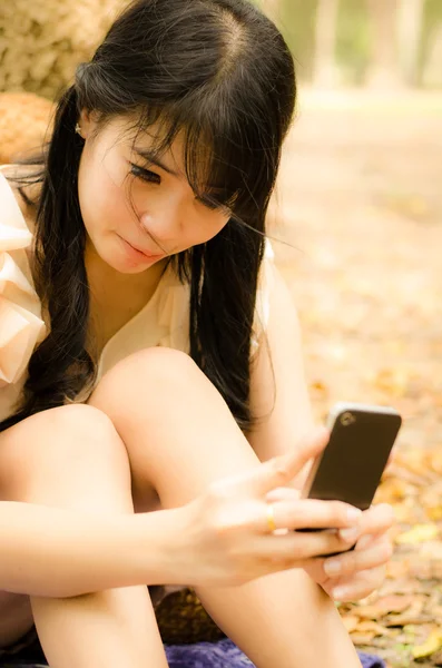 Menina asiática jogando telefone celular — Fotografia de Stock