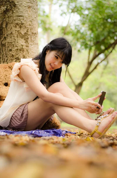 Menina asiática jogando telefone celular — Fotografia de Stock