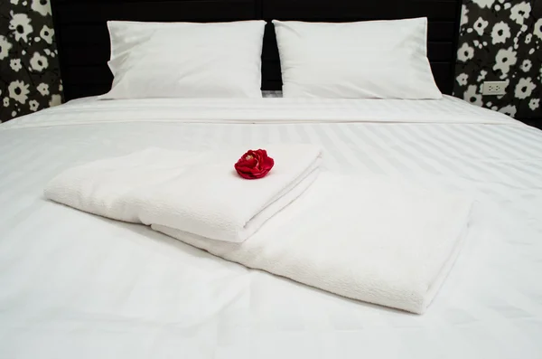 Red rose on white towel in hotel room — Stock Photo, Image