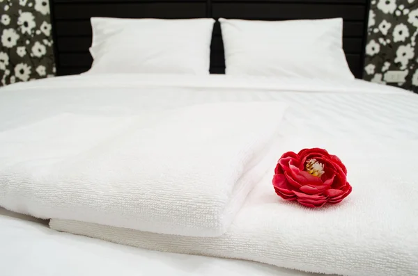 Red rose on white towel in hotel room — Stock Photo, Image