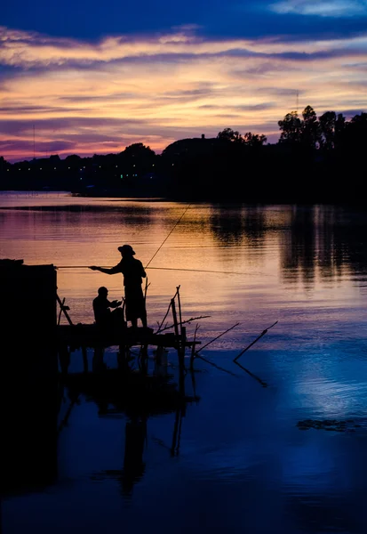 Dva rybáři siluetu proti západu slunce — Stock fotografie