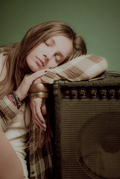 A beautiful teenage girl sleeping on a sound device — Stock Photo, Image