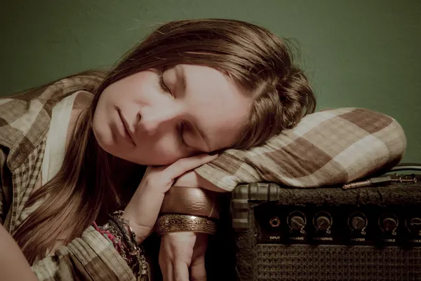 Ein schönes Teenager-Mädchen, das auf einem Soundgerät schläft Stockfoto