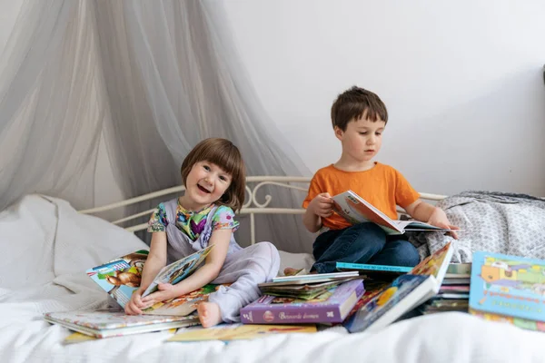 Dos hermanos leyendo libros en el sofá — Foto de Stock