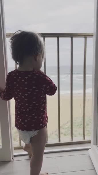 Baby Steht Der Balkontür Und Blickt Aufs Meer Während Sich — Stockvideo