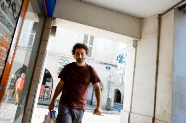 Genç bir adam bir Fransız kasabasının sokaklarında yürüyor. Güneşli hava