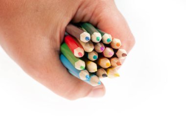 An artist holds in his hand colored pencils with graffiti in front