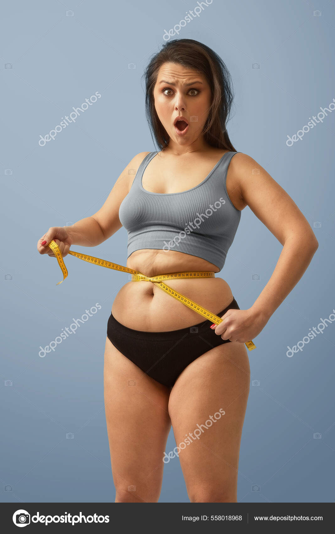 a guy with a big belly and a slim girl measuring waist measuring tape on a  white background Stock Photo