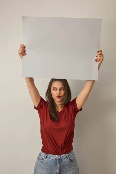 Young caucasian woman hold blank canvas above her head. Blank space for copy. Cowboy shot high quality image mock up. — Stock Photo, Image