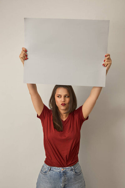 Young caucasian woman hold blank canvas above her head. Blank space for copy. Cowboy shot high quality image mock up. Royalty Free Stock Images