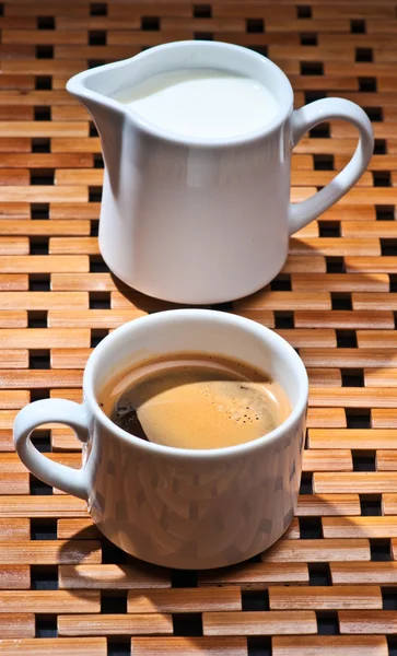 Cups of coffee and milk on wood rack