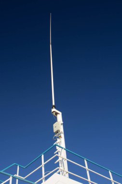 evocative image of a line ferry communication antennaunder a beautiful clear sky