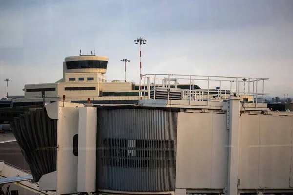 悪い日に窓から見える空港の搭乗用スリーブ又は伸縮式ガングウェイ 搭乗口 の最後の部分の感動的なイメージ — ストック写真