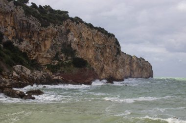Arka planda dalgalı deniz ve kıyıların canlandırıcı görüntüsü