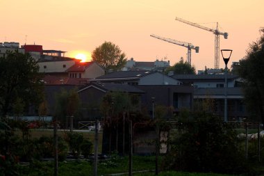 Alacakaranlıktaki bir inşaat alanındaki vinç siluetinin canlandırıcı görüntüsü. 