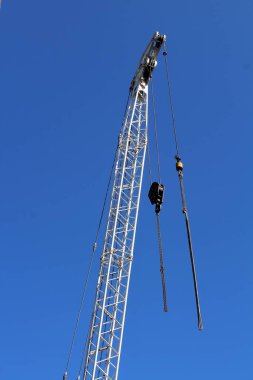 Gün batımında asılmış bir vinç kancasının canlandırıcı görüntüsü.