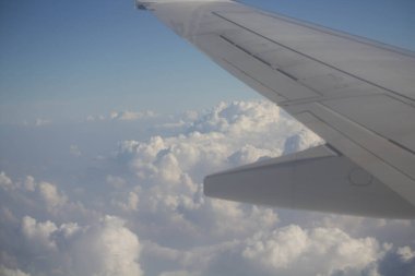 Bulutlarda uçan bir uçağın kanat kısmının canlandırıcı görüntüsü.