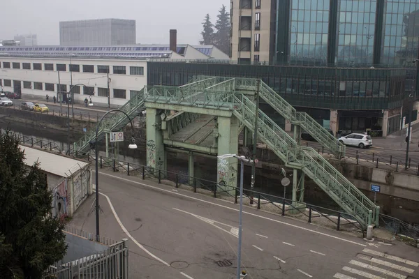 ミラノ ロレンツォ ミラニは 灰色の空の下で鉄道とセラミック工場を接続するために使用ナビリオに沿って鉄橋の感動的なイメージを越えます — ストック写真