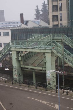 Milan, Don Lorenzo Milani üst geçidi. Naviglio boyunca uzanan demir köprünün hatırlatıcı görüntüsü. Gri gökyüzünün altındaki seramik fabrikayı demiryolu ile bağlardı.