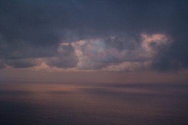 Arka planda deniz olan bir uçaktan görülen bulutların canlandırıcı görüntüsü