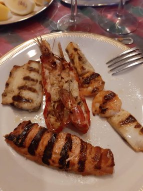 İtalyan masasında çeşitli balık türleri olan bir tabağın yakın çekimi.