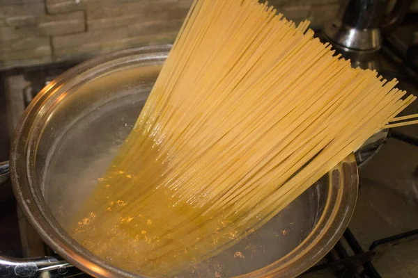 Spagettiyi kaynayan suyla dolu bir tencereye koy ve pişirilmeyi bekle.