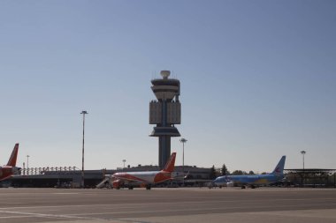 2021.10.27 Milan Malpensa Havalimanı, Easyjet Havayolları İtalya 'ya uçarken, havayolu uçağı dinlenme alanında durdu ve arka planda kontrol kulesi vardı.