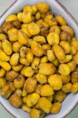 Kızarmış mısırın canlandırıcı görüntüsü, arka planda balık şeklinde mavi bir kasede aperatif olarak.