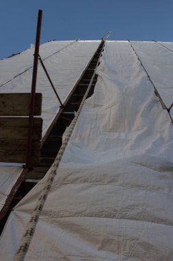 Ön cephenin bakımını sağlamak için bir binanın koruyucu iskelesine yakın plan. 