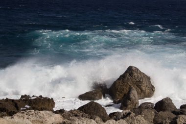 evocative image of a rough sea hitting the rocks in Sicily