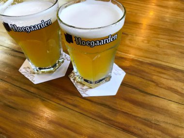 Phuket, Tayland 15 Temmuz 2011, iki fıçı Hoegaarden birası Phuket, Tayland 'da bir bira barında, ahşap bir masada çok soğuk.
