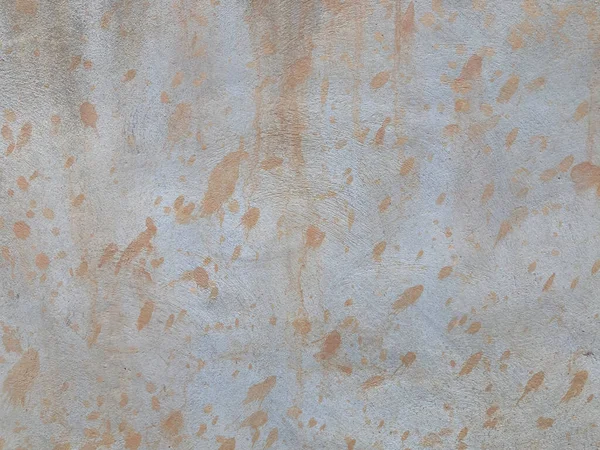 light brown dots stains are all over the white cement wall in the full frame shot