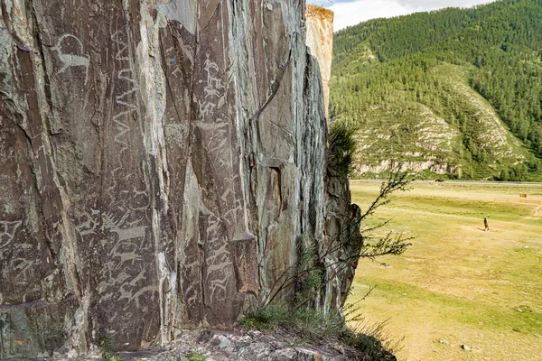 Βραχώδη γλυπτά αρχαίων ανθρώπων στο Kalbak-Tash, σε απόσταση υπάρχει η πέτρα Chuisky Deer Adyr-Kan ή Olenny πέτρα Royalty Free Εικόνες Αρχείου