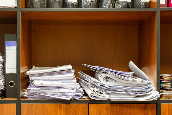 documents and working drawings of large format are sloppy on the shelf of the filing cabinet