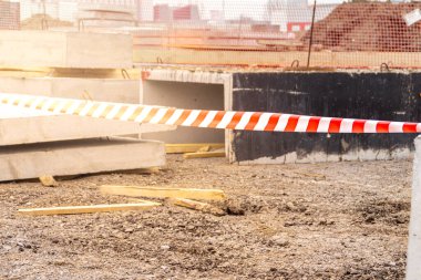 Kırmızı ve beyaz renkli parlak renkli uyarı bandı tehlikeli inşaat çalışmalarını, seçici odak noktasını tanımlar