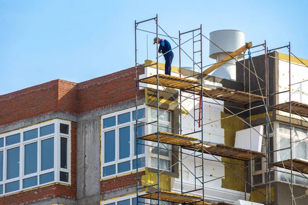 Acabado con aislamiento mineral y poliestireno de la fachada de un edificio residencial en construcción — Foto de Stock