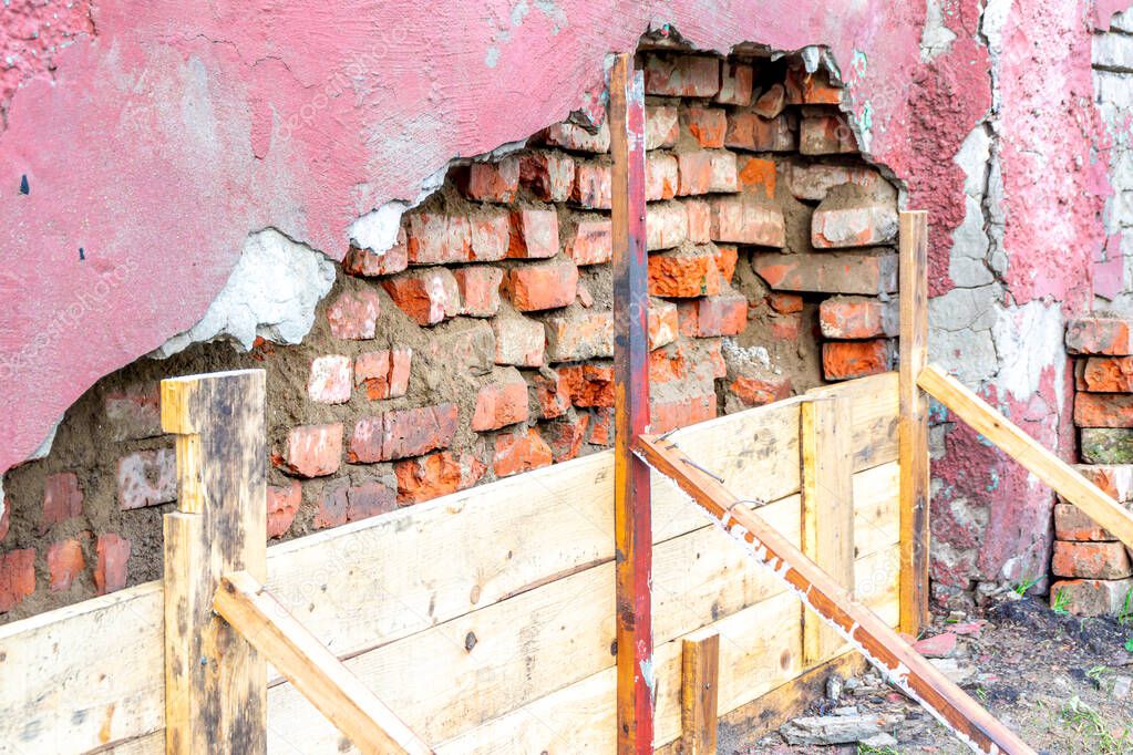 a brick wall is destroyed due to high humidity and low-quality materials used in construction, selective focus
