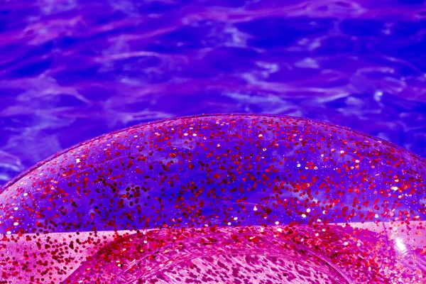 透明なインフレータブルサークルの夏の明るい輝きの背景には 苛性物質を含む水の背景に輝きがあります 紫色のネオンカラーの円のクローズアップ — ストック写真