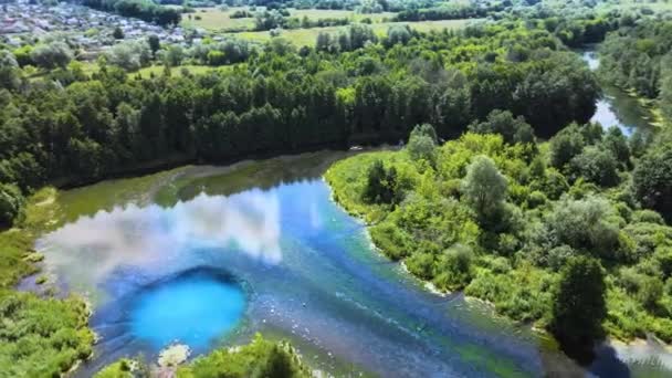 A felhők tükröződnek a tükörszerű átlátszó tóban. Kék mély víznyelő van benne. — Stock videók