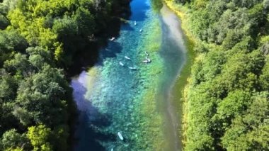 Büyük bir şirketle kamp yapmak. Ekip dolambaçlı bir orman nehrinde kürek çekiyor. Nehrin kıyıları yoğun bir şekilde ormanla kaplıdır. Güzel korunan bir bölgede temiz hava ve temiz su. İnsansız hava aracı görüntüleri