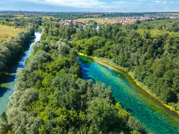 Kırsal bölgedeki göl ve nehir manzarası. Çevre dostu konutlar ve doğa ile insan arasındaki uyumlu komşuluk kavramı. Banliyö hayatının avantajları.