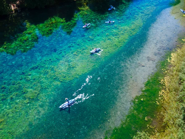 Ellerinde kürekler, şeffaf bir orman nehrinin akıntısında süzülüp giden tahtırevanlar. Spor yaşam tarzı ve açık hava aktiviteleri kavramı. Aile hafta sonu kaçamağı.