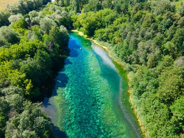 Orman gölündeki bir grup pansiyonerin helikopter fotoğrafı. İnsanlar sakin bir şekilde güzel nehri keşfediyor ve muhteşem doğanın tadını çıkarıyorlar. Sakinlik, sessizlik ve meditasyon havası..