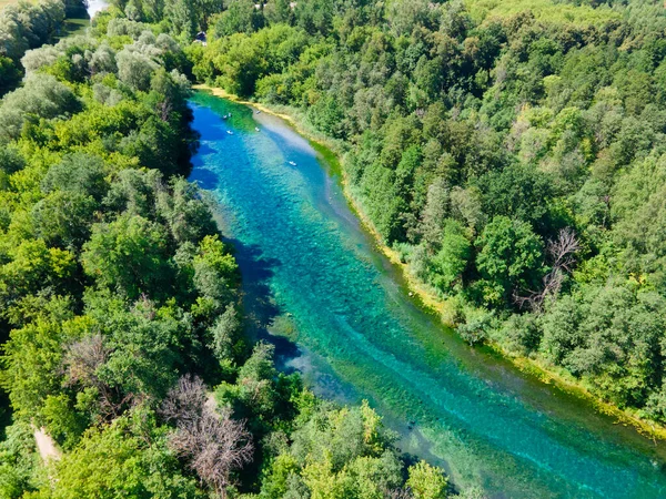 Yaprak döken ormandaki bir gölün kuş bakışı görüntüsü. Rezervuarın uzun bir şekli var. Temiz suyun içinden kumlu zemini görebilirsiniz, alglerle kaplanmış. Çevre dostu açık hava eğlencesi.