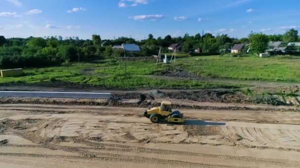 Roller-zagęszczarka kompakty i spłaszcza glebę podczas budowy nowej drogi — Wideo stockowe