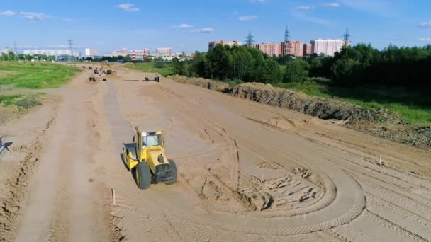 Жовті роликові компакерні фільми на піщаному будівельному майданчику в Москві. — стокове відео