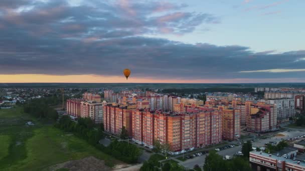 Фестиваль повітряних куль у вечірньому місті. Він пливе на відстані над будинками — стокове відео