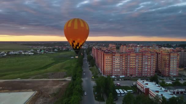 Drone moves around air balloon. Cinematic evening landscape with dramatic sky — Stockvideo